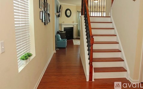 A hallway with a staircase and a blue couch.