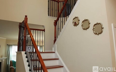 A staircase with a wooden handrail and white steps.