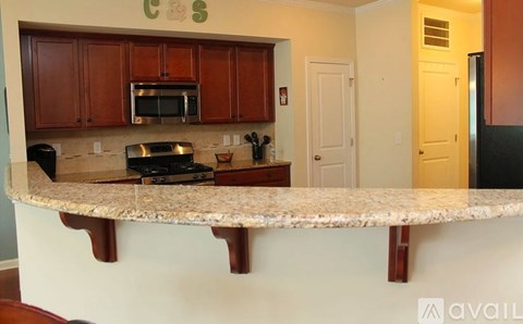 A kitchen with brown cabinets and a granite countertop.