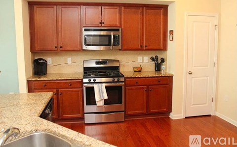 A kitchen with wooden cabinets and a stainless steel stove.