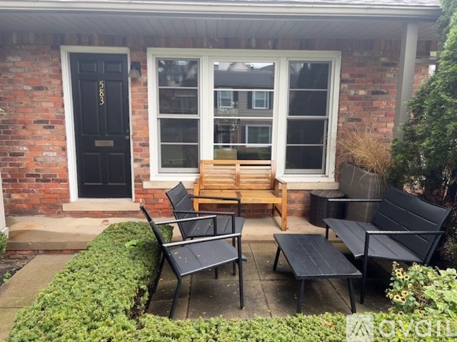 A black bench and chair set is on a patio.