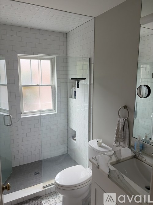 A bathroom with a toilet, sink, and shower.