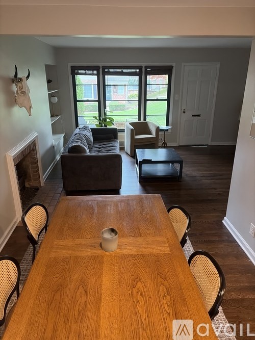 A dining room with a wooden table and chairs.