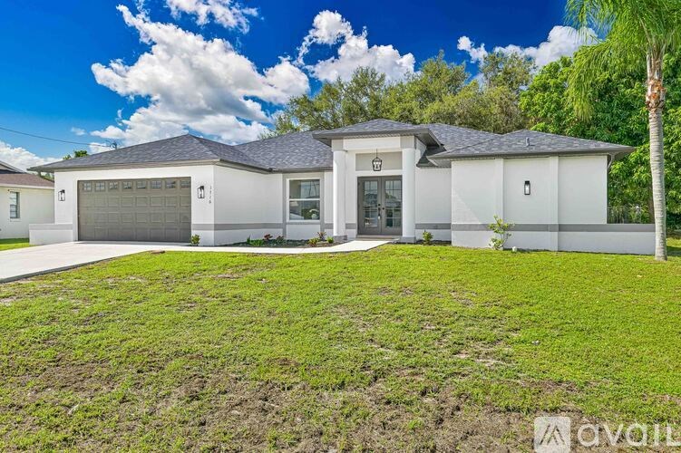 A white house with a grey roof and a garage door.