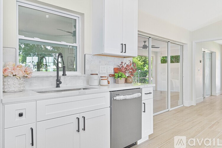 A kitchen with white cabinets and a stainless steel dishwasher.