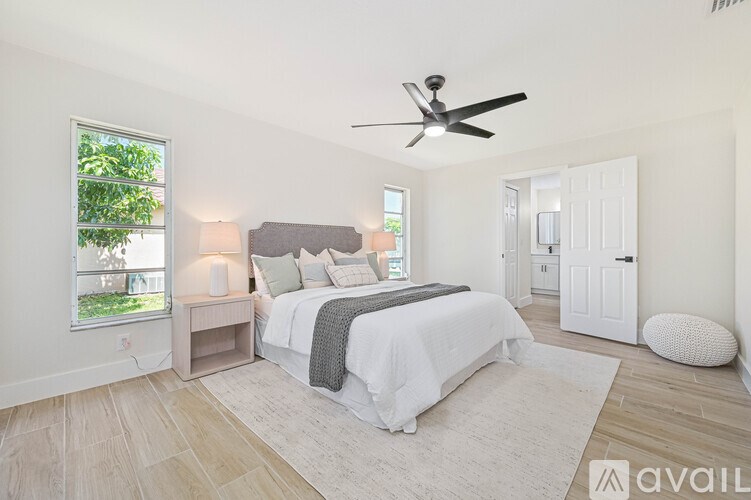 A bedroom with a large bed and a ceiling fan.