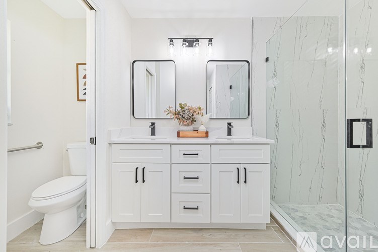 A bathroom with a white toilet and a marble wall.