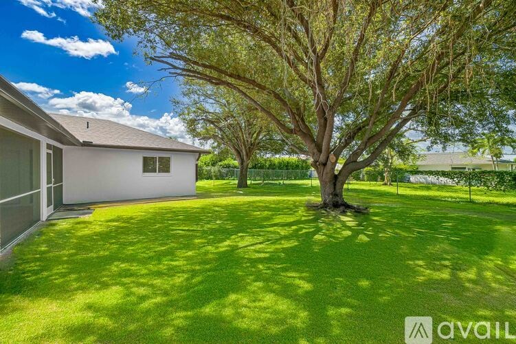 A tree in a yard in front of a house.