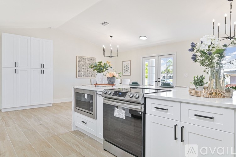 A kitchen with white cabinets and a stove top oven.