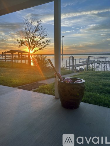 A sunset view from a balcony with a drink on the table.