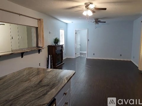 A spacious room with a wooden countertop and a ceiling fan.