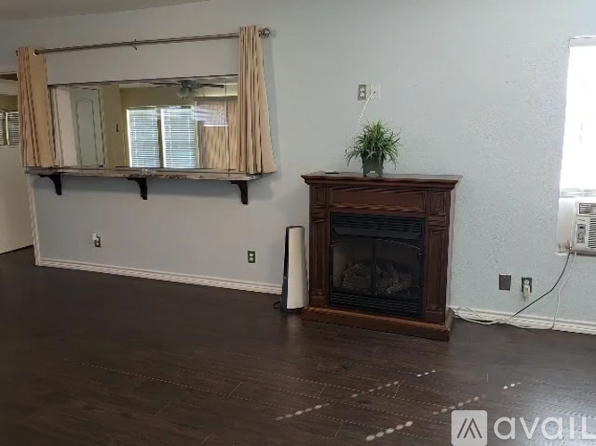 A living room with a fireplace and a mirror on the wall.