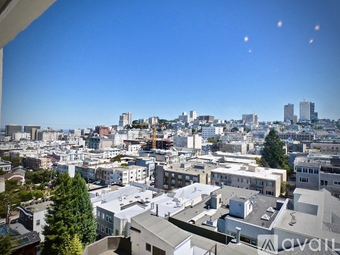 A cityscape with buildings of various sizes and a clear blue sky.