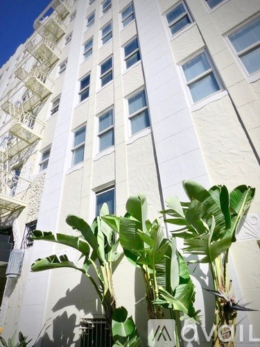 A tall white building with a fire escape on the side.