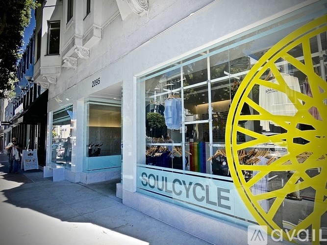 A storefront with a large yellow wheel design and the word "SOULCYCLE" on the window.