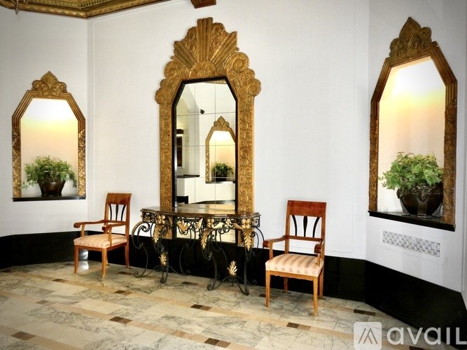 A room with a table, chairs and mirrors.