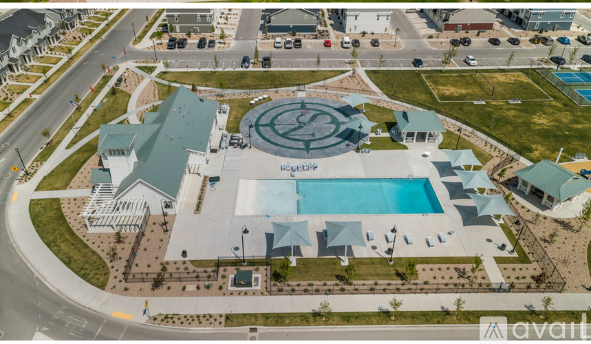 An aerial view of a building with a pool and a parking lot.