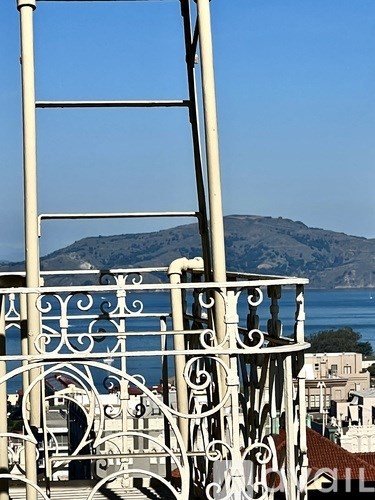 A white metal railing with a mountain in the background.