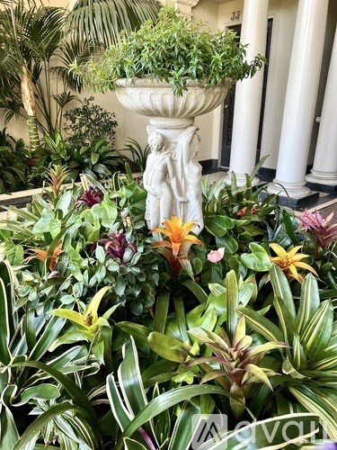 A large planter with a statue in the middle of a garden.