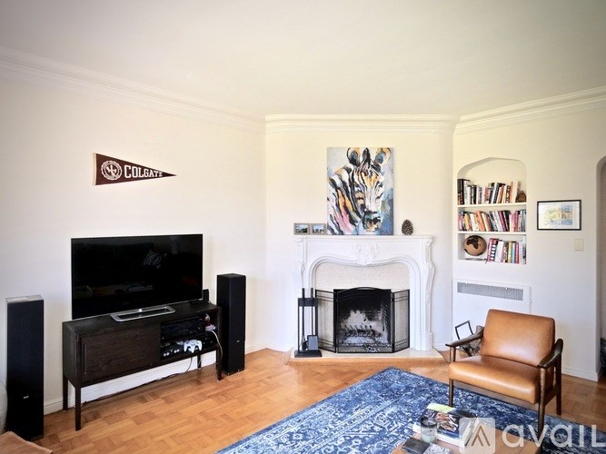 A living room with a fireplace and a painting of a tiger above it.