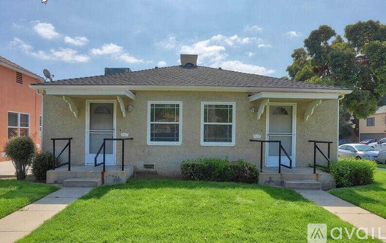 A two-story house with a front porch and a well-maintained lawn.