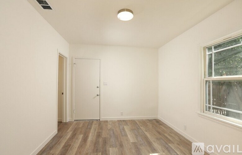 A room with a window and wooden flooring.