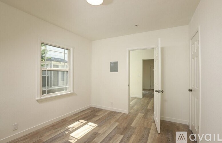 A room with a window and wooden flooring.