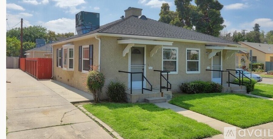 A house with a red door and a green roof is for sale.