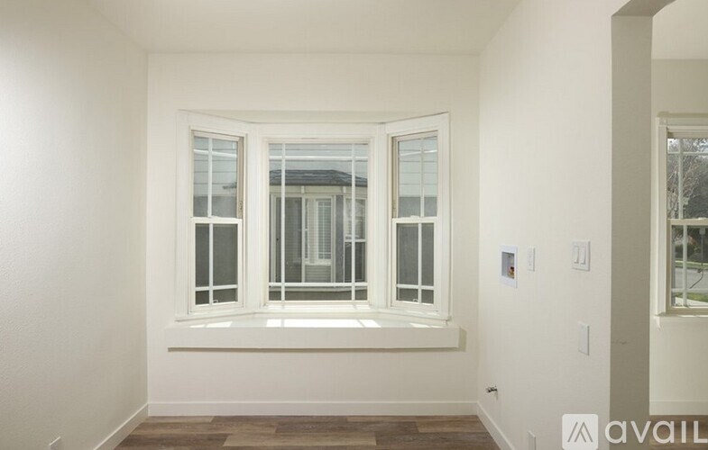 A room with a large window and a wooden floor.