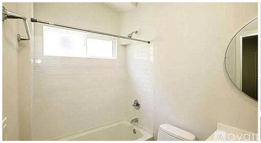 A bathroom with a toilet, sink, and a window.