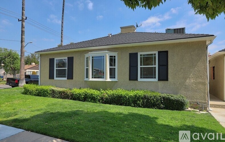 A house with a well-maintained lawn and a clear sky above.