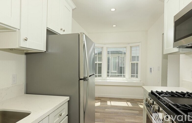 A modern kitchen with a stainless steel refrigerator and a stove top oven.