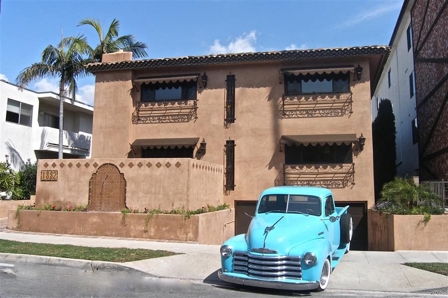 an old blue car parked in front of a building