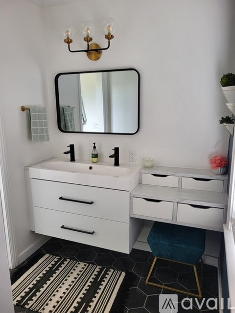 A bathroom with a sink, mirror, and a rug.