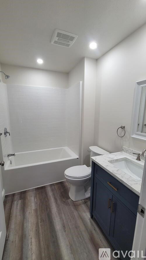 A bathroom with a toilet, sink, and bathtub.