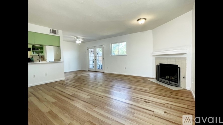 A spacious living room with a fireplace and hardwood flooring.