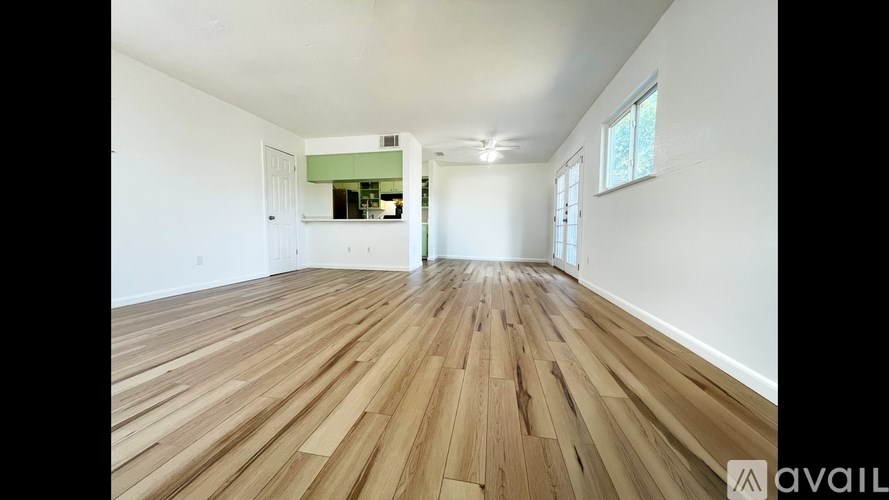 A room with wooden flooring and white walls.