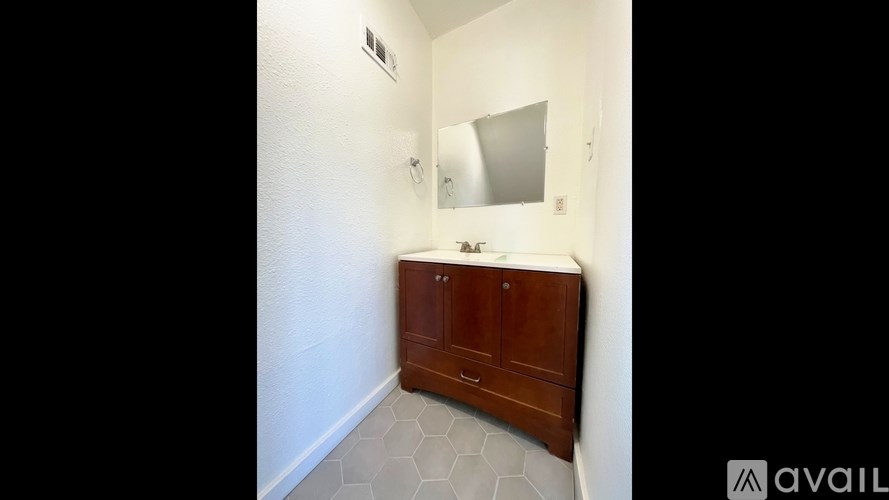 A wooden cabinet with a mirror above it in a room.