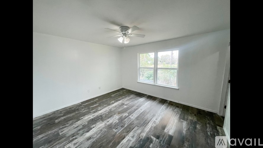 A room with a ceiling fan and a window.