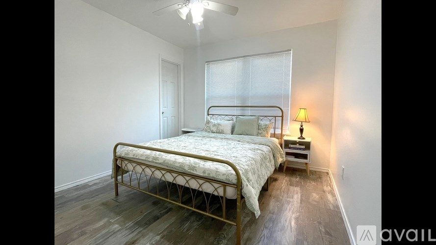 A bedroom with a bed, nightstand, and window.
