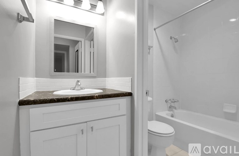 A bathroom with a sink, mirror, toilet and bathtub.