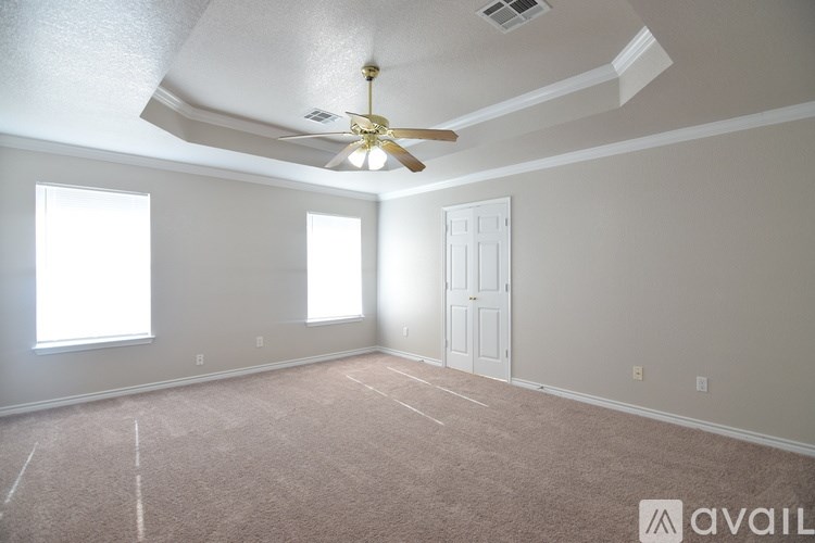 A room with a ceiling fan and carpeted floor.