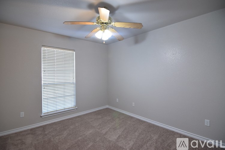 A room with a ceiling fan and a window with blinds.