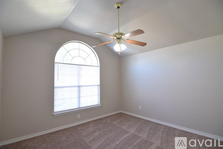 A room with a fan and a window.