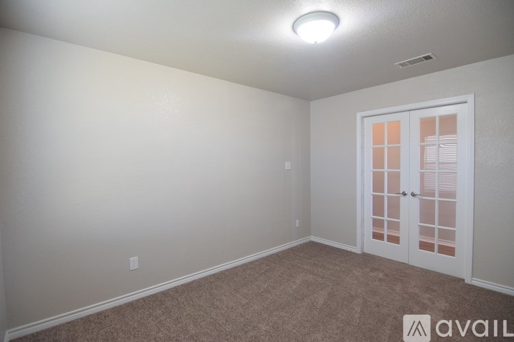A room with a carpeted floor and a white door.
