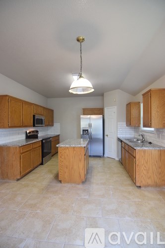 A kitchen with wooden cabinets and a tiled floor.