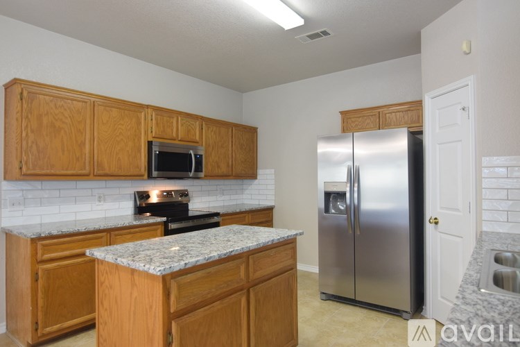 A kitchen with wooden cabinets and a granite countertop.