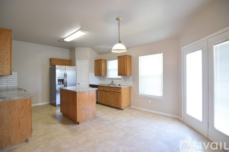A kitchen with wooden cabinets and a granite countertop.