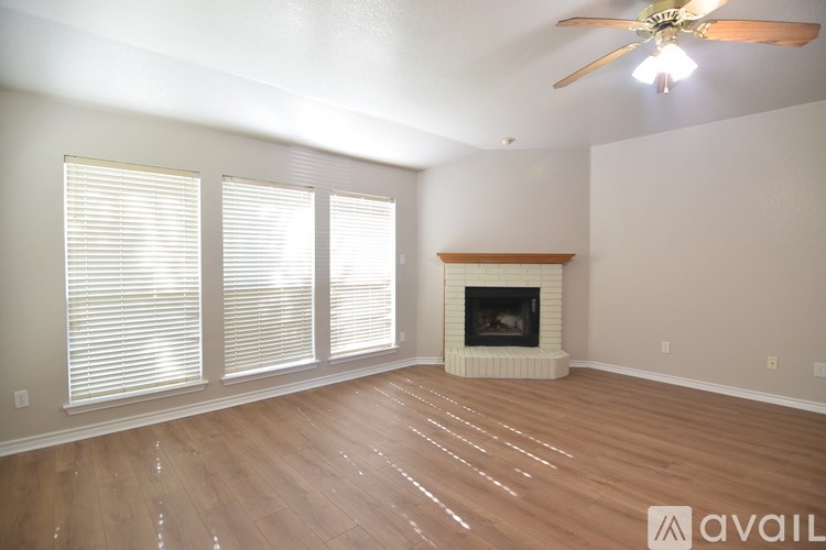 A living room with a fireplace and a ceiling fan.