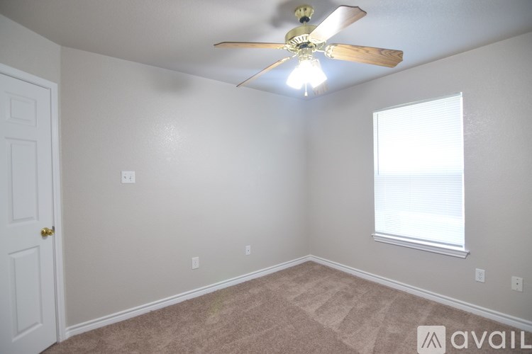 A room with a ceiling fan and a window.